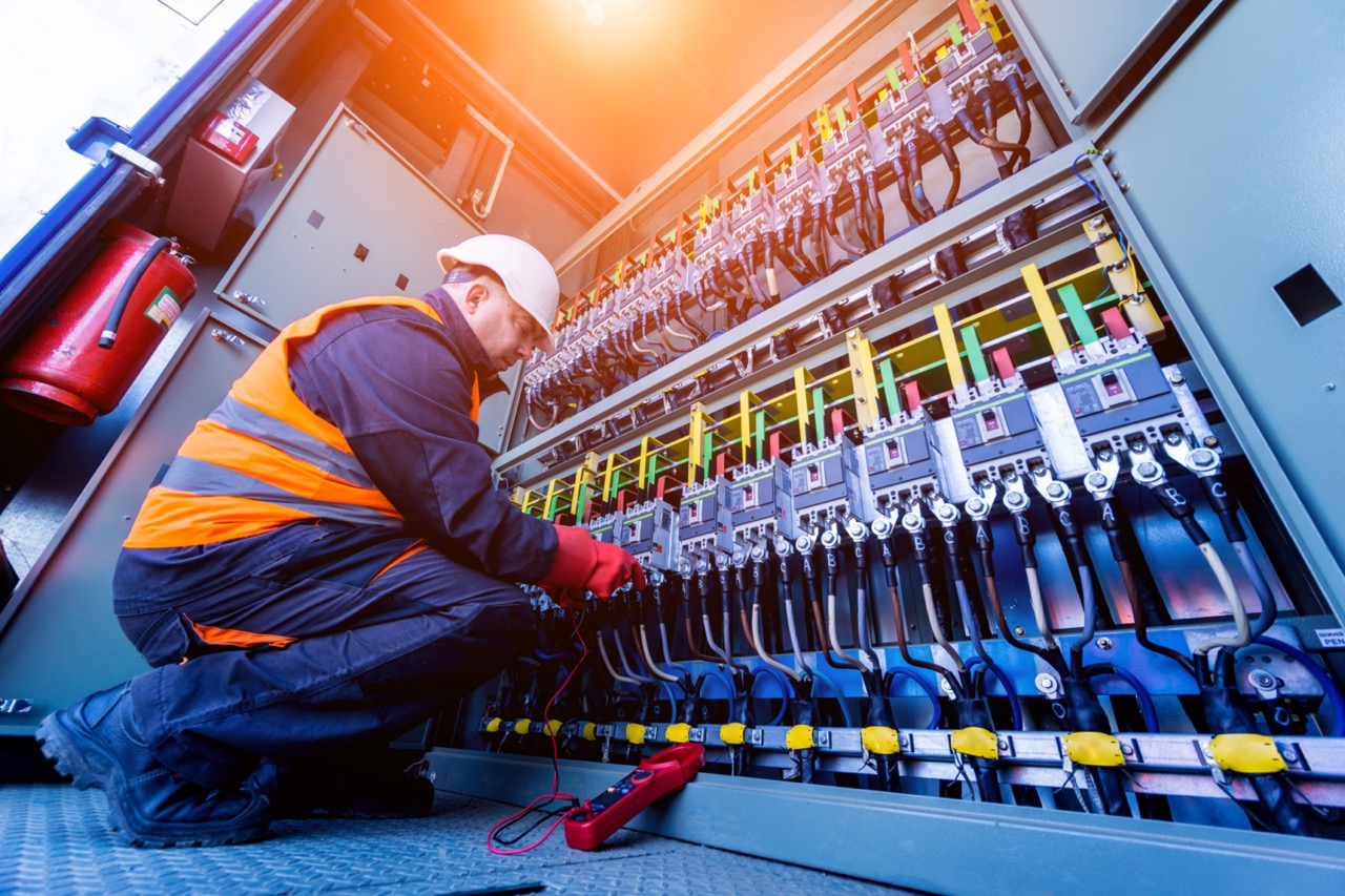 Field service worker checking the operating voltage levels of the solar panel switchgear compartment